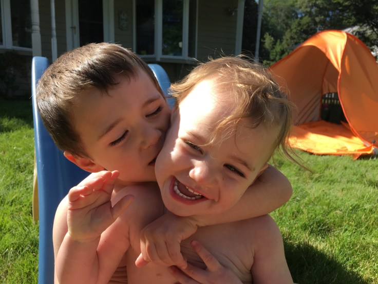 toddler siblings kissing