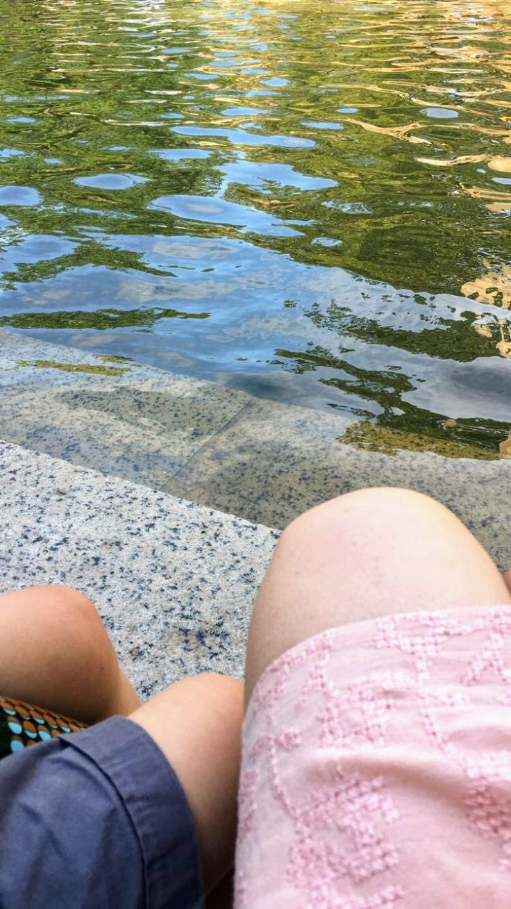 Mom and son sitting by fountain