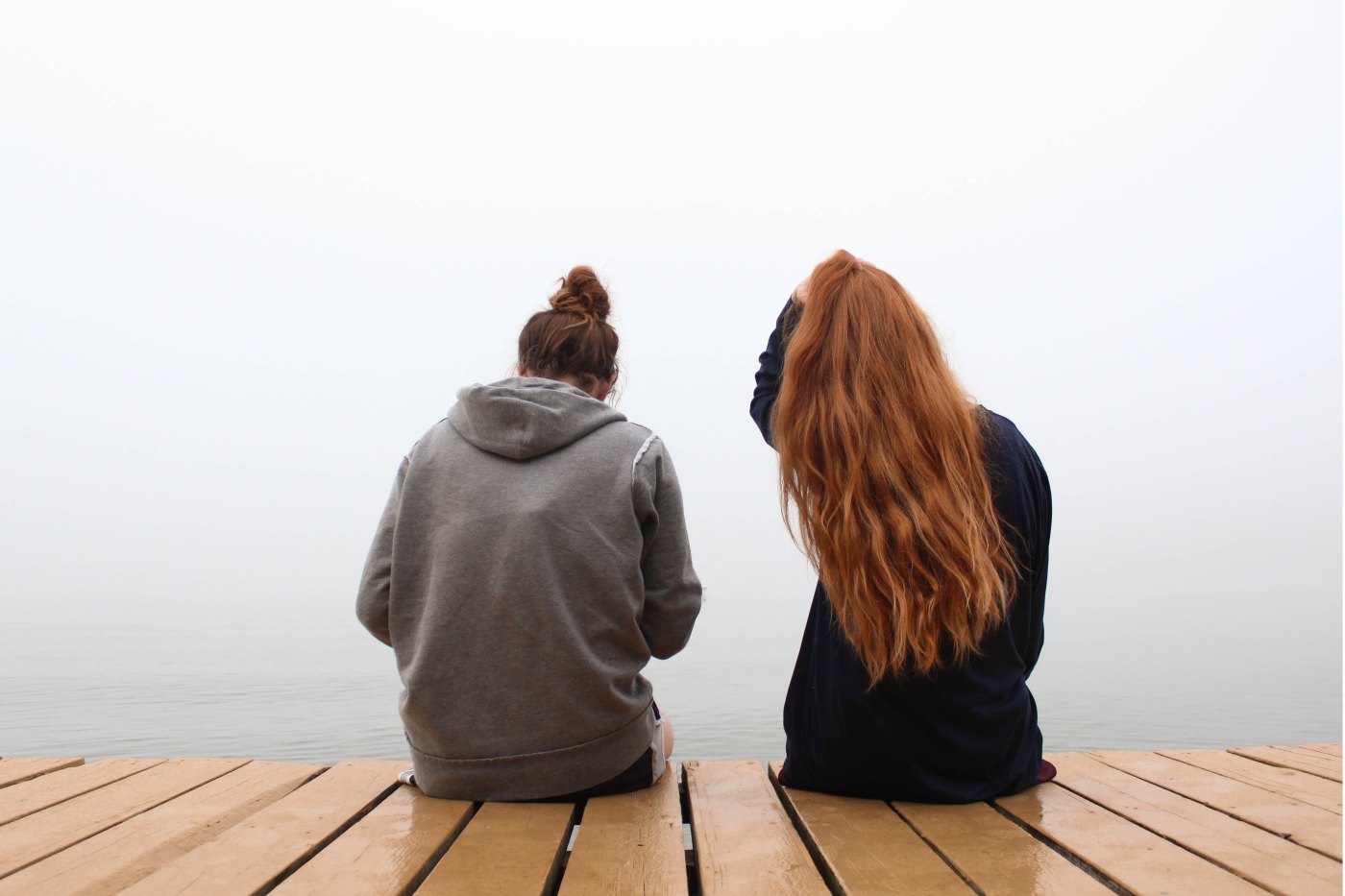 Two friends sitting on a dock