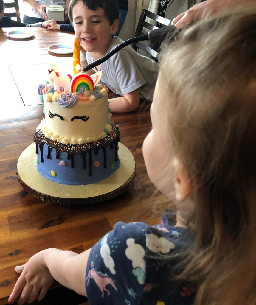 About to blow candles of unicorn cake